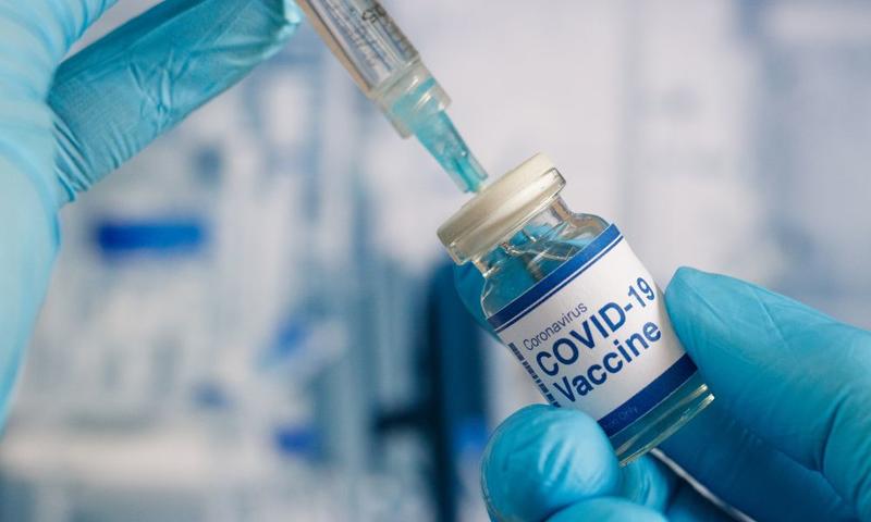 close up shot of a covid vaccine and a syringe