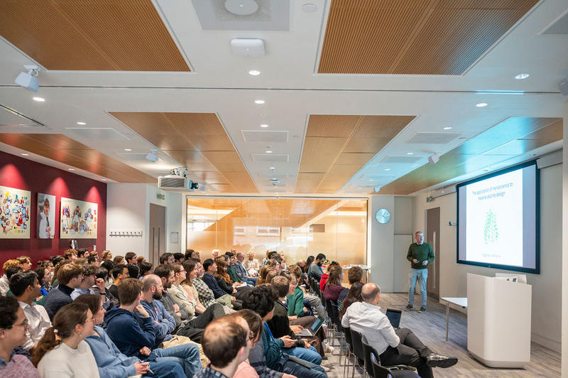 Seated delegates listen to Professor Matt Higgins giving the keynote lecture, titled 'The application of nanoscience to malaria vaccine design', at the 5th birthday symposium held by Oxford's Kavli Institute for Nanoscience Discovery.