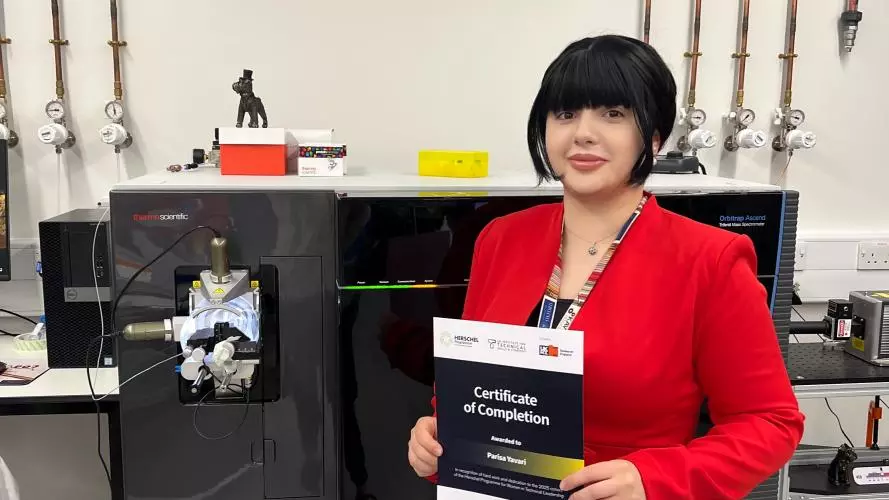 A photo of Parisa holding her certificate of completion