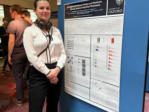 A photograph of Anna Olerinyova with her poster.